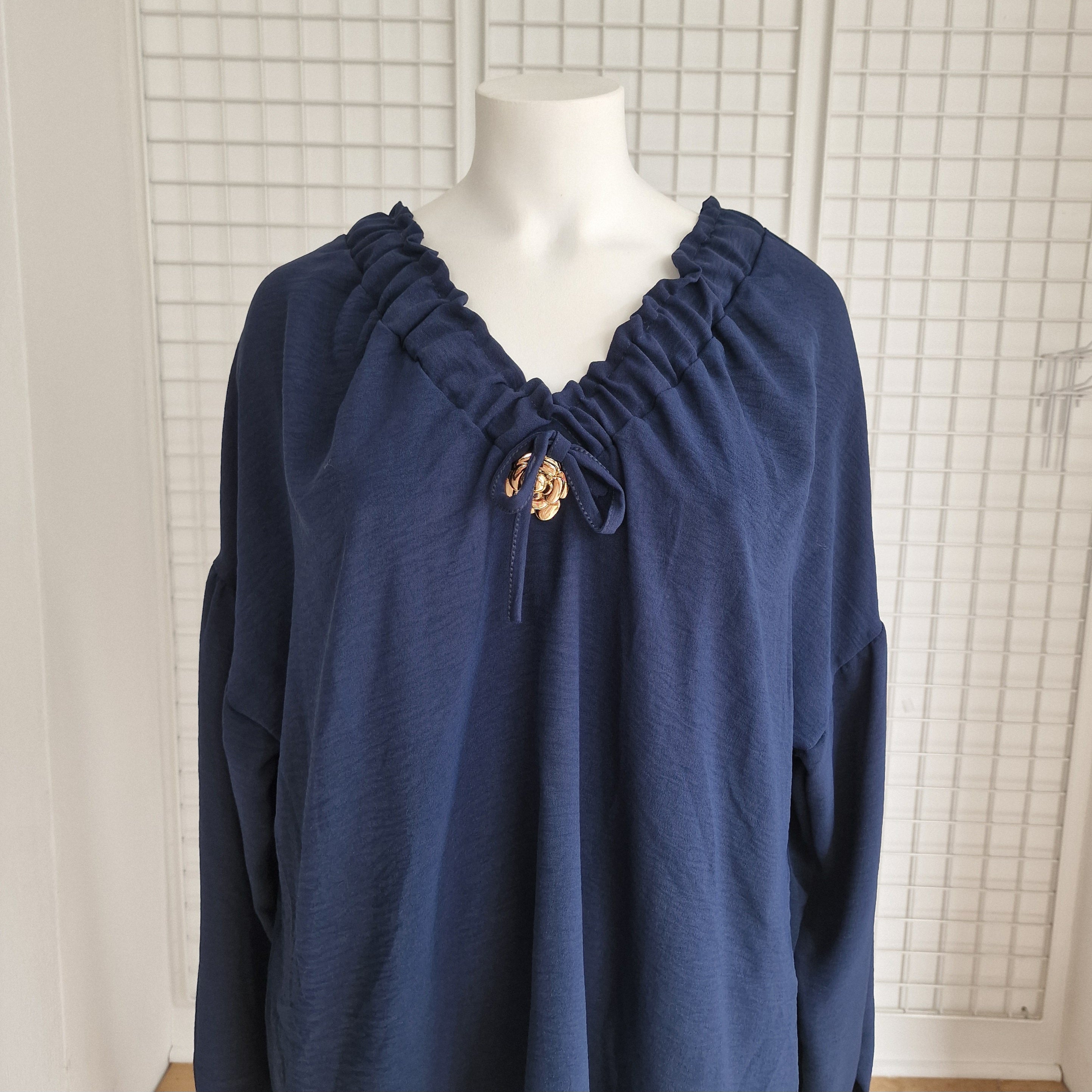 Tunique avec noeud et broche