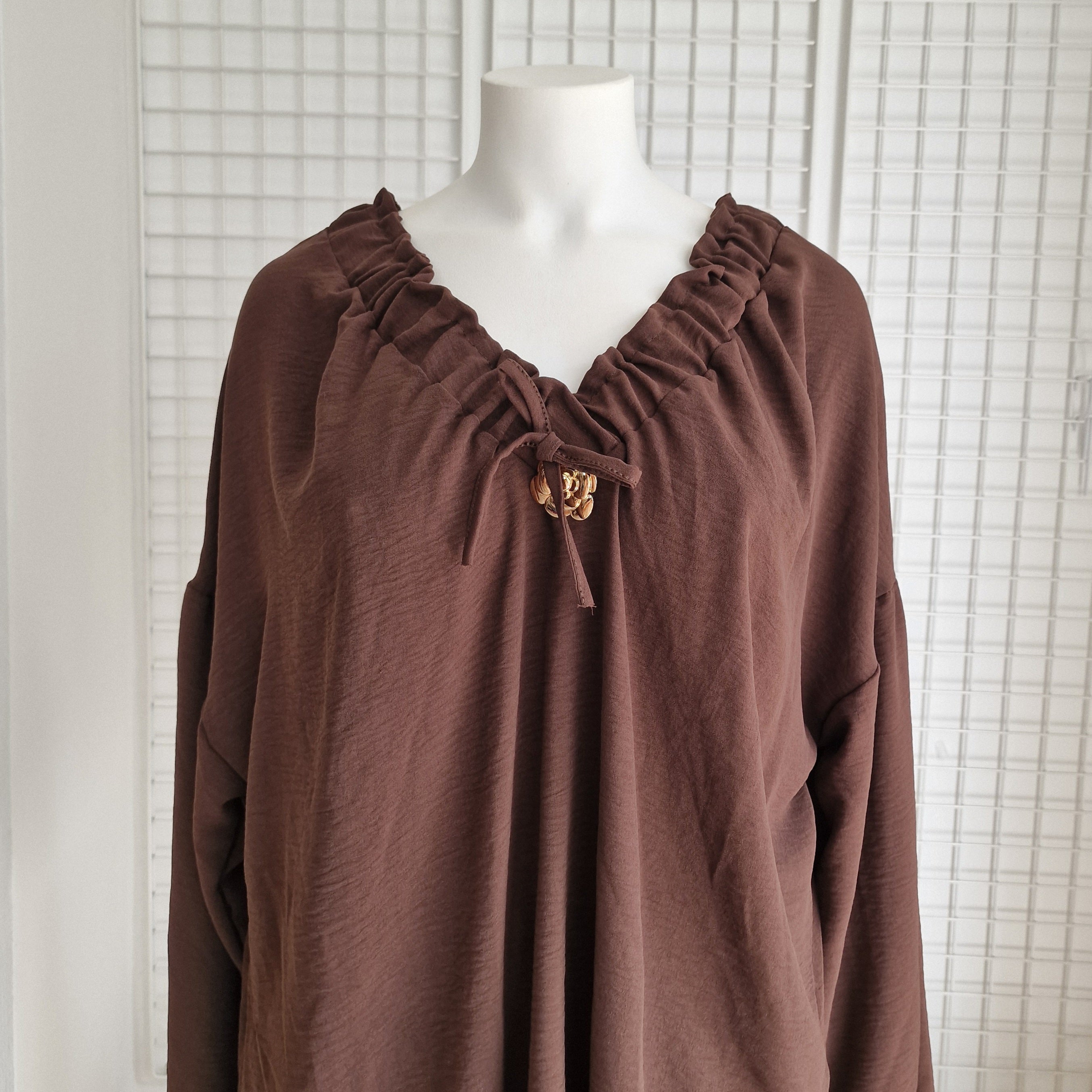 Tunique avec noeud et broche