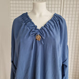 Tunique avec noeud et broche